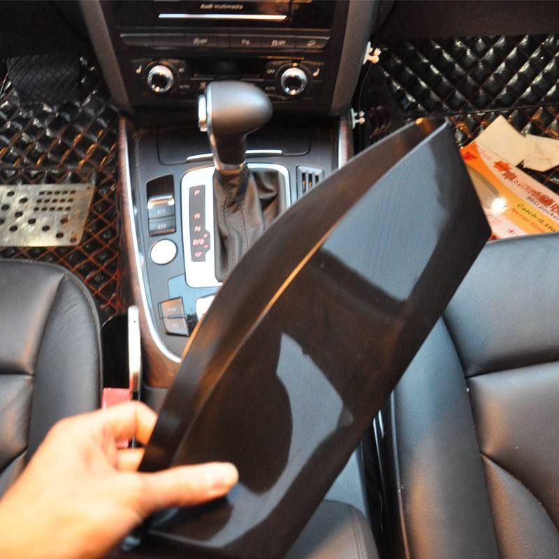 Car seat gap storage box being fitted beside a seat