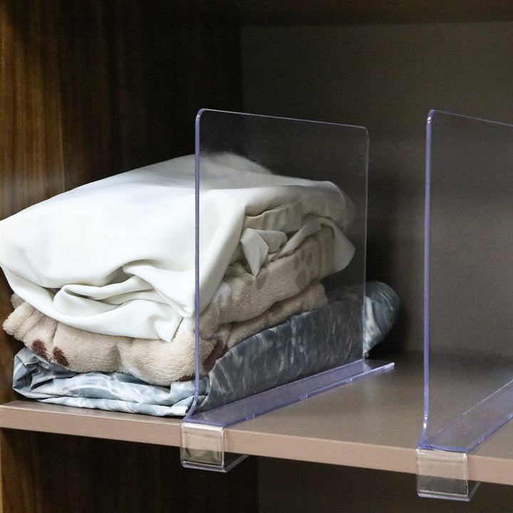 Clear magnetic shelf divider separating folded linen on a wardrobe shelf
