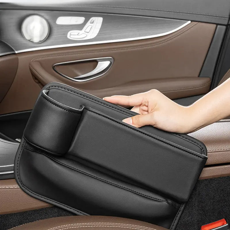 Hand reaching into car seat gap organiser pocket